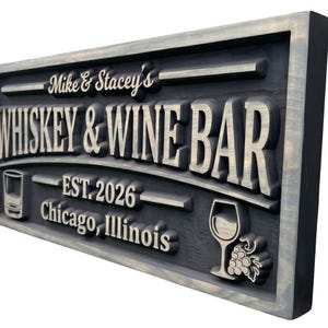 Peut inclure: Panneau rectangulaire en bois avec les mots "Whiskey & Wine Bar" en lettres en relief de couleur claire. Le panneau comprend le texte "Mike & Stacey's", "EST. 2026" et "Chicago, Illinois". Un verre et un verre à vin sont également représentés.