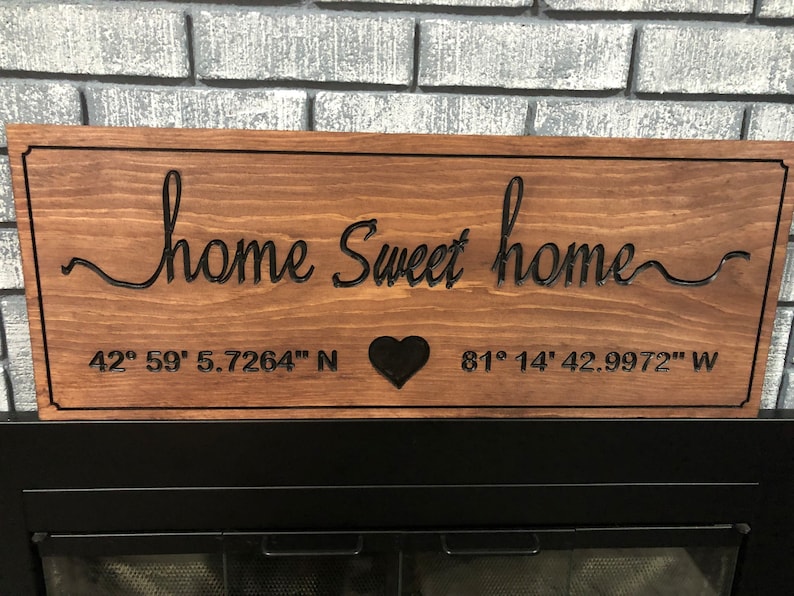 Peut inclure: Panneau en bois marron avec l'inscription "home Sweet home" en &eacute;criture cursive. Le panneau comporte &eacute;galement un c&oelig;ur noir et des coordonn&eacute;es : 42&deg; 59' 5.7264" N et 81&deg; 14' 42.9972" W. Forme rectangulaire.