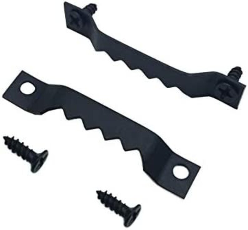 May include: Two black metal picture hanging hooks with four black screws. The hooks have a serrated edge and two holes for hanging.