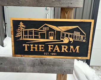 May include: Wooden sign with a farm scene carved into it. The sign is rectangular with a dark background and a light brown border. The words "THE FARM" and "EST. 1991" are carved into the wood.