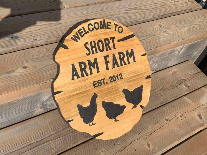 May include: A wooden sign with the text "Welcome to Short Arm Farm Est. 2012" and three black silhouettes of chickens.