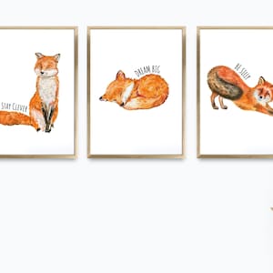 Puede incluir: Tres impresiones enmarcadas con ilustraciones de acuarela de zorros. La primera impresión presenta un zorro sentado con el texto "Stay Clever". La segunda impresión presenta un zorro acurrucado durmiendo con el texto "Dream Big". La tercera impresión presenta un zorro estirándose con el texto "Be Silly".