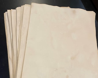 May include: A stack of blank, off-white paper sheets with a slightly textured surface.