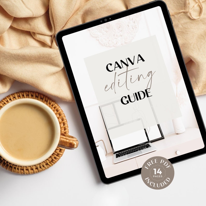 May include: A digital tablet displaying a Canva editing guide with the text "CANVA editing GUIDE" and "FREE PDF 14 PAGES INCLUDED". The tablet is on a white surface with a cup of coffee and a beige blanket in the background.