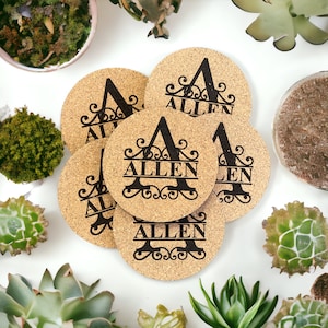 Puede incluir: Seis posavasos de corcho con un diseño de monograma personalizado. Cada posavasos presenta una gran letra "A" con el nombre "ALLEN" escrito debajo en una fuente decorativa.