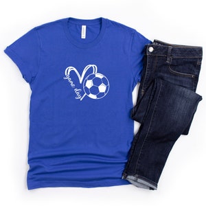 May include: A royal blue t-shirt with a white soccer ball and the text "game day" in a heart shape.