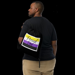 May include: A black drawstring bag with a yellow, purple, and white stripe design. The bag has the text "Proud Dad" printed on it.