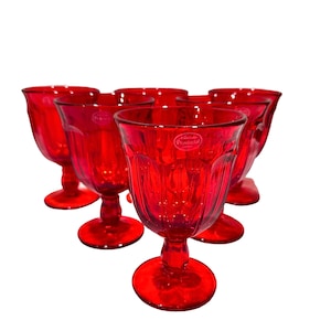May include: Set of six red glass goblets with a textured design. The goblets have a short stem and a wide bowl. The goblets are made by Provincial.