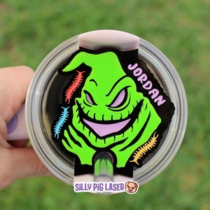 Puede incluir: Personaje verde y morado de Oogie Boogie de Pesadilla antes de Navidad con el nombre Jordan sobre un fondo blanco. El personaje sostiene una pajita. La imagen es para un vaso personalizado.
