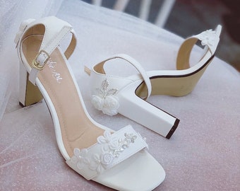 White wedding shoes with roses on the straps and heels. Beautiful high heels for the bride,Party shoes .