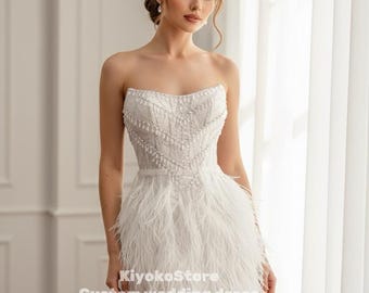 May include: A strapless white wedding dress with a beaded bodice and a feathered skirt. The dress is short, ending above the knees. The text "KiyokoStore Custom wedding dress" is visible.