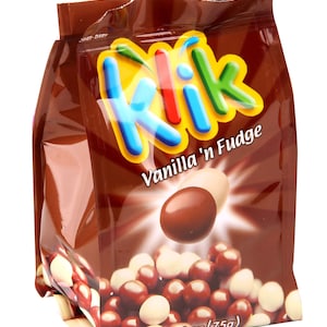 Könnte beinhalten: Eine Tüte Klik Vanilla 'n Fudge Schokoladenbonbons. Die Tüte ist braun mit einem bunten Klik-Logo und dem Text "Vanilla 'n Fudge". Die Tüte enthält eine Mischung aus weißen und braunen Schokoladenbonbons. Die Tüte wiegt 75 Gramm (2,64 Unzen).