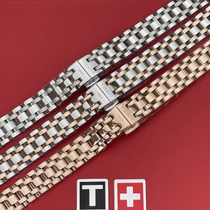 May include: Three watch bands in silver, rose gold, and gold tones. Each band has a repeating link pattern and features the Tissot logo and the year 1853.