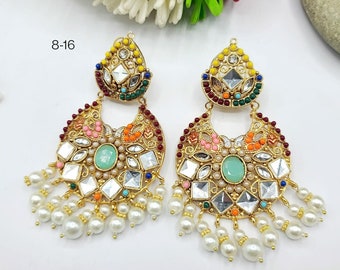 May include: A pair of gold-tone earrings with a crescent moon design. The earrings are adorned with colorful stones and beads, including turquoise, pink, orange, and green. The earrings have a dangling pearl drop.