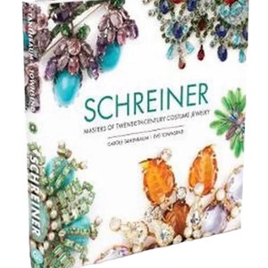 May include: A book titled "Schreiner: Masters of Twentieth-Century Costume Jewellery" by Carole Tanenbaum and Eric T. Schrader. The cover features colourful close-up images of vintage costume jewellery.