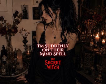 May include: A black lace-trimmed camisole with a black robe. The text reads: I'M SUDDENLY ON THEIR MIND SPELL THE SECRET WITCH. The garment features thin straps and delicate lace detailing along the neckline and hem, worn in a dimly lit room.