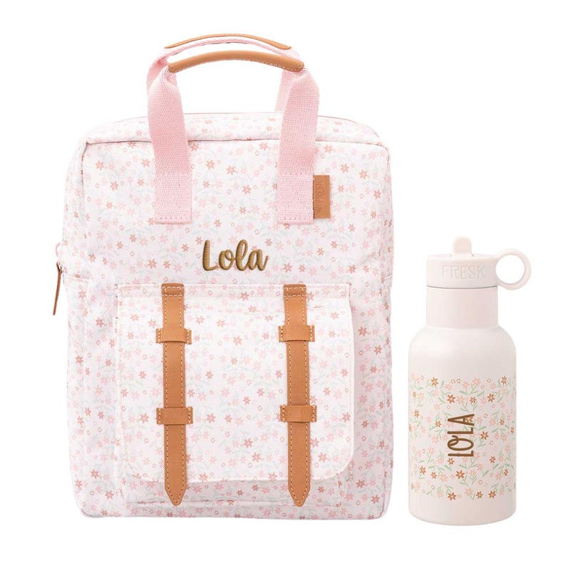May include: A pink floral backpack and matching water bottle. The backpack has a front pocket with brown straps and the name "Lola" in gold lettering. The water bottle also features the name "Lola" and a floral design.