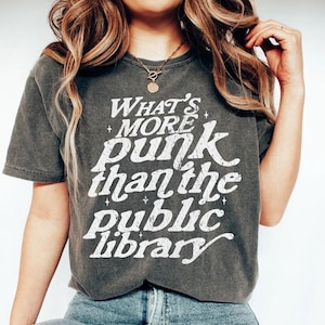 May include: A grey t-shirt with a white graphic that reads "What's more punk than the public library".