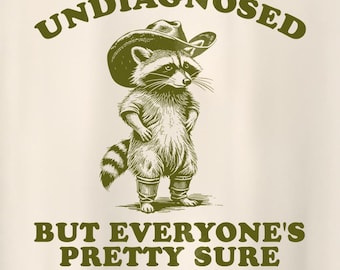 May include: A green graphic design of a raccoon wearing a cowboy hat with the text "UNDIAGNOSED BUT EVERYONE'S PRETTY SURE" on a white background.