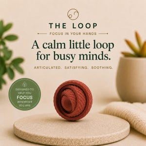May include: A terracotta-coloured, spherical fidget toy with a textured, diamond-patterned surface. The text reads: THE LOOP, FOCUS IN YOUR HANDS, A calm little loop for busy minds. ARTICULATED. SATISFYING. SOOTHING. DESIGNED TO HELP YOU FOCUS WHEREVER YOU ARE.