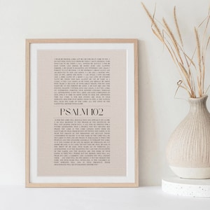 Puede incluir: Una impresión enmarcada del Salmo 102 de la Biblia. El texto está impreso en negro sobre un fondo beige claro con un patrón de cuadrícula sutil. El título "Salmo 102" está impreso en un tamaño de fuente más grande en la parte inferior de la impresión.