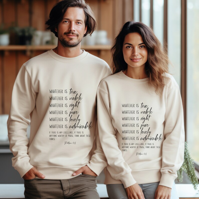 K&ouml;nnte beinhalten: Beigefarbener Crewneck-Pullover mit dem Text "Whatever is true, whatever is noble, whatever is right, whatever is pure, whatever is lovely, whatever is admirable. If there is any excellence, if there is anything worthy of praise, think about these things. Philippians 4:8" in Schwarz gedruckt.