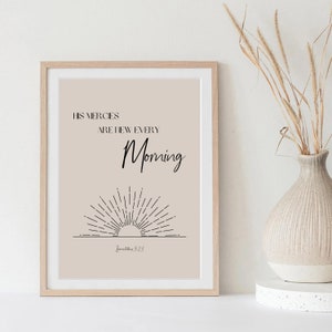 May include: A beige printable wall art print with black text that reads "His mercies are new every morning" and a black line drawing of a sun rising above a horizon. The text "Lamentations 3:23" is written below the drawing.