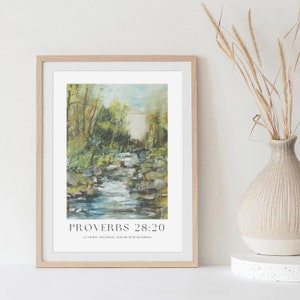 Op de afbeelding: Een ingelijste print met een schilderij van een beek die door een bos stroomt. De print heeft de tekst "Spreuken 28:20" en de quote "Een getrouwe man zal overvloedig gezegend worden".