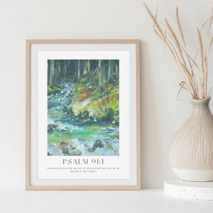 Può includere: Una stampa incorniciata con un dipinto di un ruscello che scorre attraverso un bosco. La stampa include il testo "PSALM 91:1" e il versetto "Chi dimora sotto la protezione dell'Altissimo riposa all'ombra dell'Onnipotente."