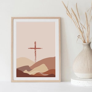 May include: A digital art print featuring a red cross over a landscape of brown, beige, and white hills. The background is a light pink color.