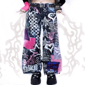 May include: Wide-leg pants featuring a black and white checkered pattern, star and heart graphics, and text prints. The pants include a black belt, a silver chain, and various fabric patches in pink, blue, and purple, paired with black platform shoes.