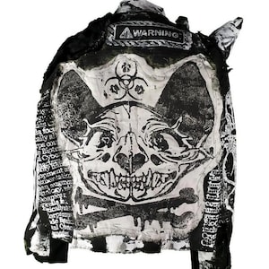 May include: Black and white denim jacket with a skull and crossbones design and the word "WARNING" on the back.
