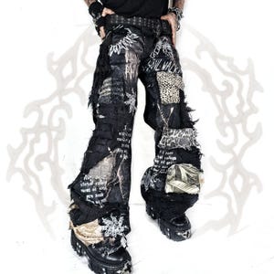 May include: Black denim pants featuring a distressed, patchwork design with frayed edges, leopard print fabric inserts, and white printed text including the phrase "SOUL WALKER". The pants have a wide-leg silhouette and are paired with black platform boots.