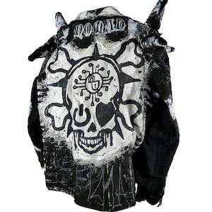 May include: Black and white denim jacket with a skull and crossbones design, a lock and key symbol, and the word "NOMAD" written on the back.