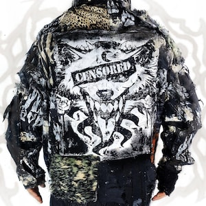 May include: A black and white jacket featuring a large back graphic of a wolf with the text CENSORED across its eyes. The garment is constructed from various textured panels, including leopard print, distressed fabric, and faux fur accents.