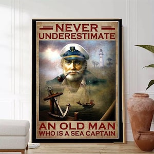 Könnte beinhalten: Ein Vintage-Poster mit dem Zitat "Unterschätze niemals einen alten Mann, der ein Seemann ist". Das Poster zeigt eine Cartoon-Illustration eines älteren Mannes mit Bart, der einen Kapitänshut trägt und eine Pfeife raucht. Der Hintergrund ist eine Seelandschaft mit einem Leuchtturm und einem Schiff.