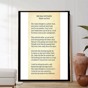 Könnte beinhalten: Ein Vintage-Druck von Robert Frosts Gedicht "The Road Not Taken" auf cremefarbenem Hintergrund. Das Gedicht ist in schwarzer Tinte gedruckt und in einem schwarzen Rahmen gerahmt.