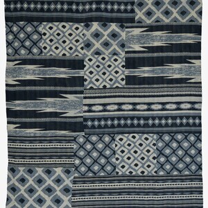 May include: A blue and white patterned throw blanket with a patchwork design. The blanket is made of a soft, woven fabric and has a variety of geometric patterns.