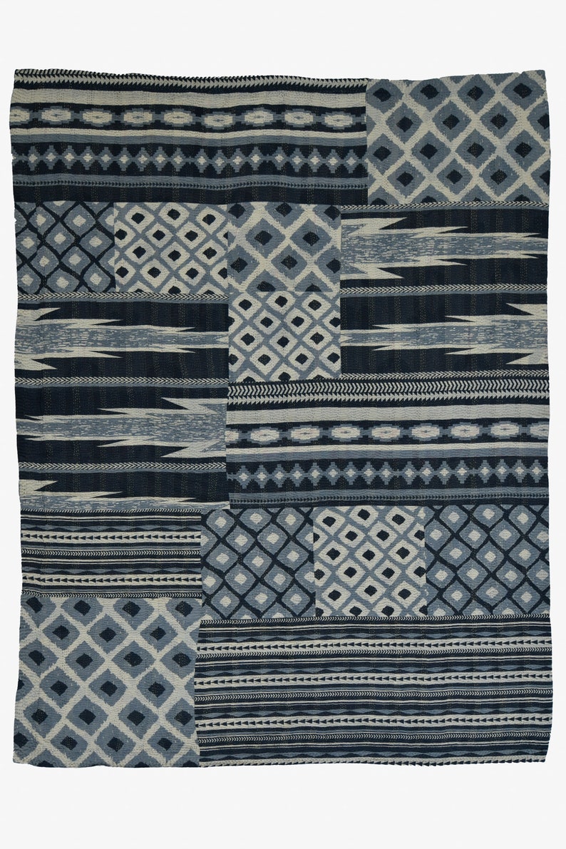 May include: A blue and white patterned throw blanket with a patchwork design. The blanket is made of a soft, woven fabric and has a variety of geometric patterns.