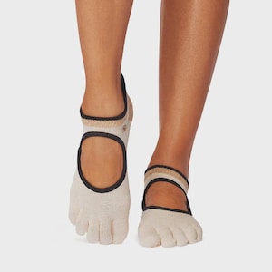 May include: A pair of beige five-toe socks featuring a large circular cutout on the top of the foot, a black trim around the opening, and a ribbed ankle cuff with alternating beige and black horizontal stripes. The socks cover the toes individually.