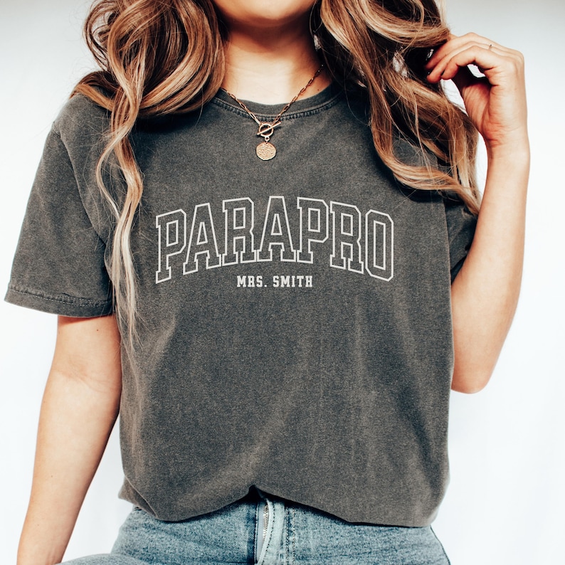 May include: A gray t-shirt with the text "PARAPRO MRS. SMITH" in white.