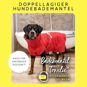 May include: A black dog wearing a red hooded towel bathrobe. The towel is labeled "Bademantel "Towlie"" and has the text "Rückenlänge 25-85 CM". The text "Auch für Anfänger geeignet" is in a speech bubble.
