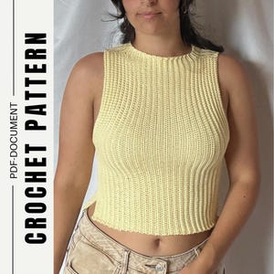 May include: A pale yellow sleeveless crochet top with a ribbed texture and a round neckline. The text CROCHET PATTERN PDF-DOCUMENT is printed vertically on the left side of the image. The top has a cropped length and a straight hemline.