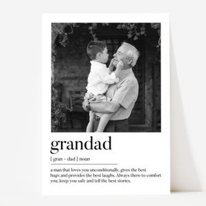 May include: Black and white print featuring a grandfather holding a young child. The print includes the word "grandad" with a definition below. The definition describes a man who loves unconditionally and provides comfort.