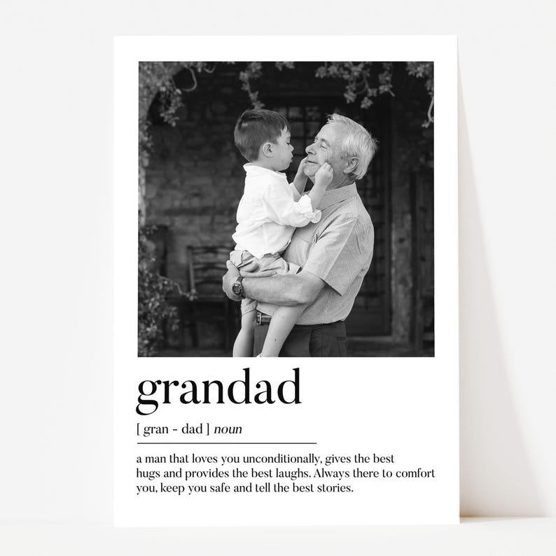 May include: Black and white print featuring a grandfather holding a young child. The print includes the word "grandad" with a definition below. The definition describes a man who loves unconditionally and provides comfort.