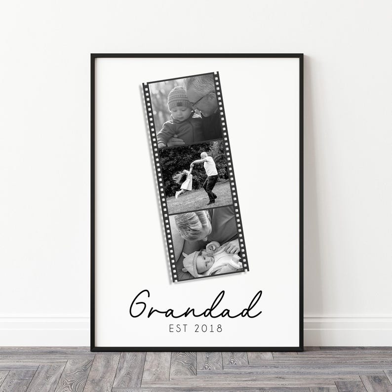May include: Black and white framed print featuring a film strip of three family photos. The word "Grandad" is written in cursive below the photos, with "EST 2018" underneath. The frame is black, and the background is white.