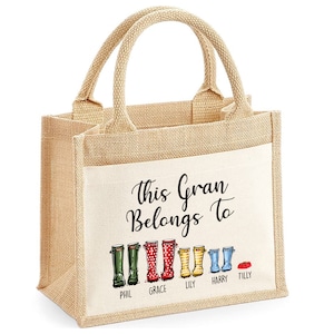May include: A natural jute tote bag with a white cotton panel. The panel features the text "This Gran Belongs To" and a line of colorful rain boots with names below each boot: Phil, Grace, Lily, Harry, and Tilly.