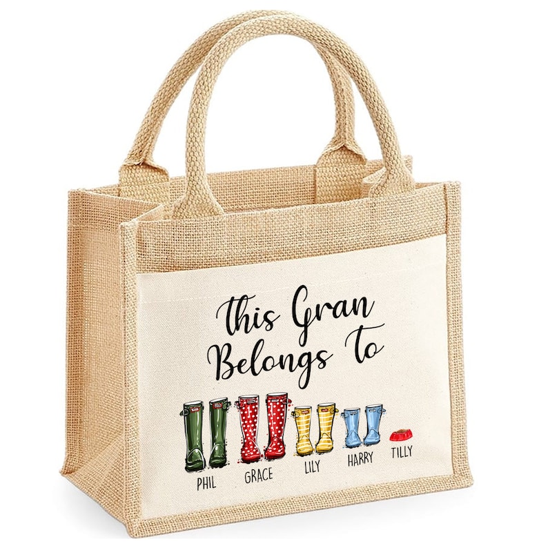 May include: A natural jute tote bag with a white cotton panel. The panel features the text "This Gran Belongs To" and a line of colorful rain boots with names below each boot: Phil, Grace, Lily, Harry, and Tilly.