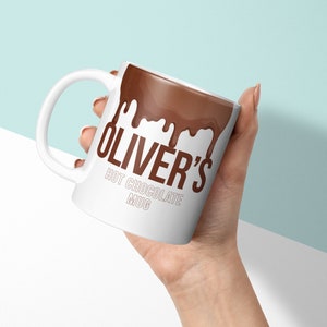 May include: White ceramic mug with a brown chocolate drip design and the text "Oliver's Hot Chocolate Mug".