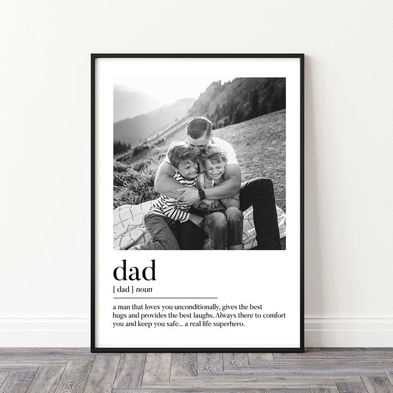 Peut inclure: Impression en noir et blanc encadr&eacute;e avec une photo d'un homme &eacute;treignant deux enfants. Le mot "dad" et sa d&eacute;finition sont imprim&eacute;s en dessous. Le fond montre un paysage de montagne.